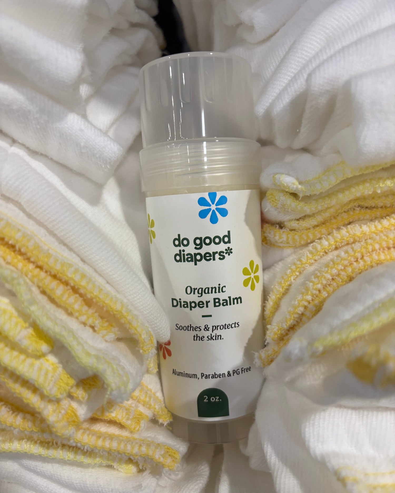 Bottle of 'do good diapers' organic diaper balm on a white and yellow textured surface